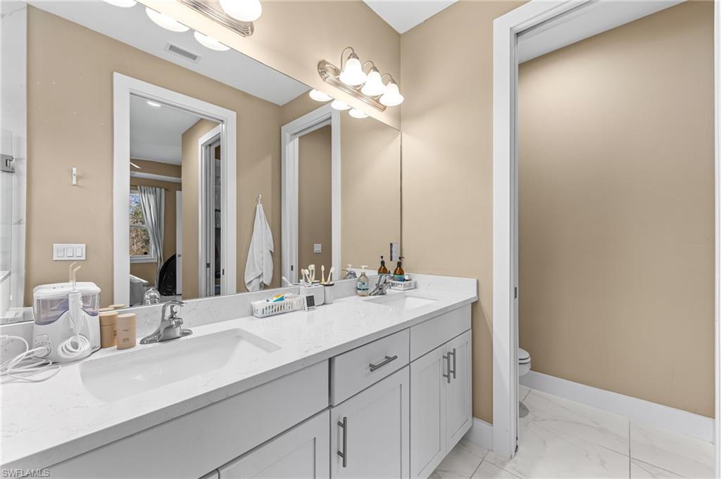 2793 72nd Avenue Northeast Naples, FL 34120 - Photo 30 of 50 a bathroom with a sink vanity and a mirror