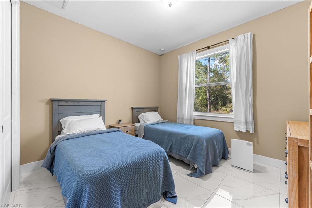 2793 72nd Avenue Northeast Naples, FL 34120 - Photo 31 of 50 a bedroom with two beds and a large window