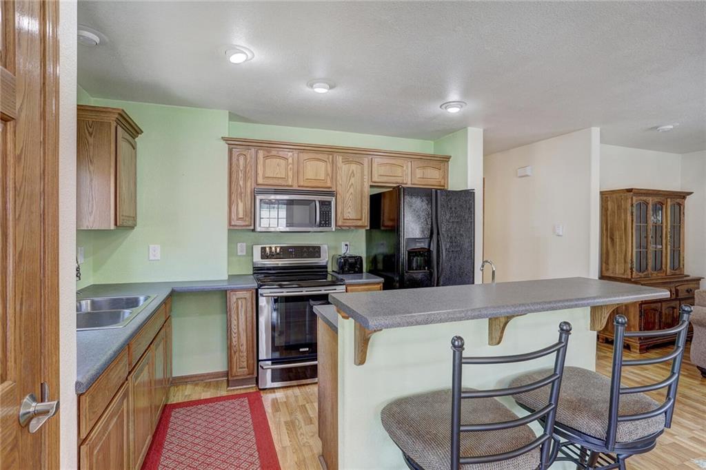 47 West Hansen Road Keystone, CO 80435 - Photo 15 of 35 a kitchen with stainless steel appliances granite countertop a stove a sink dishwasher a microwave oven and a refrigerator with wooden floor