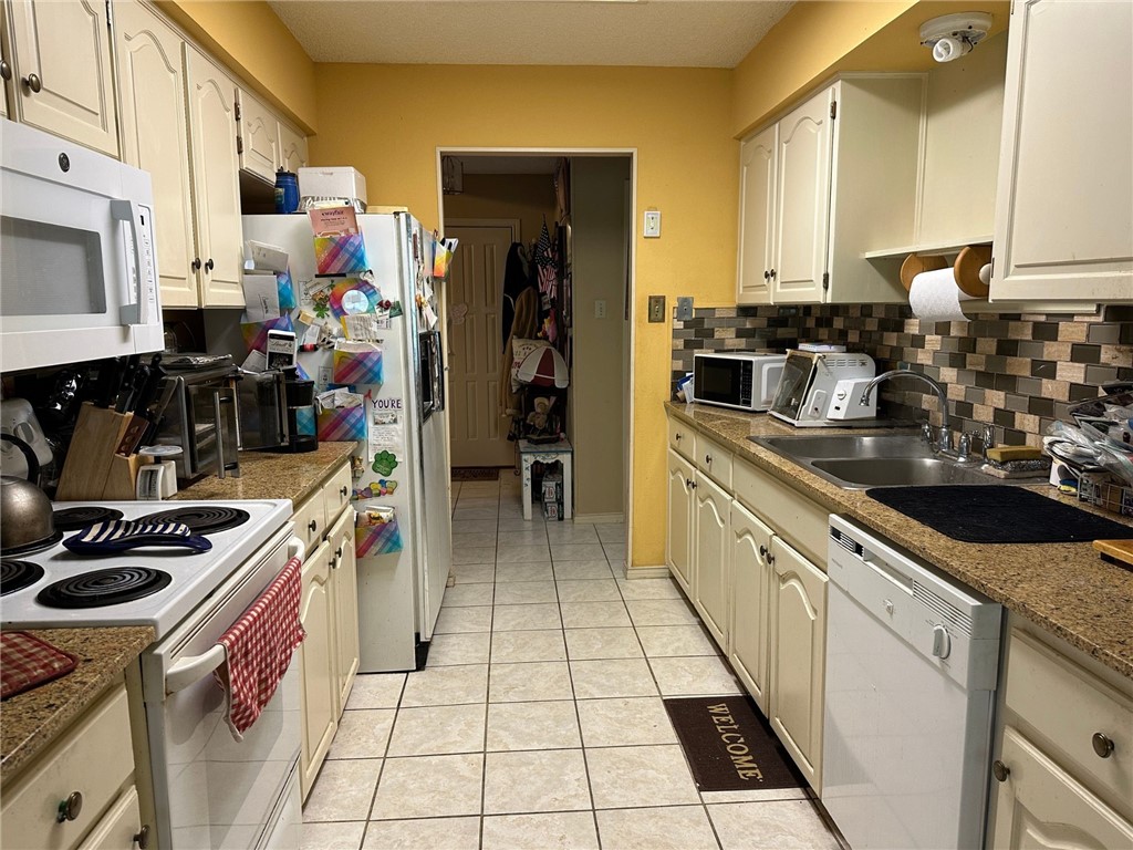 7322 Pepper Ridge Road Corpus Christi, TX 78413 - Photo 3 of 11 a kitchen with stainless steel appliances a sink stove top oven and cabinets