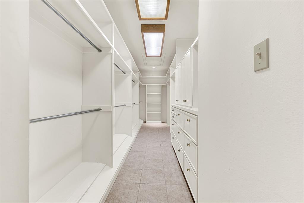 933 Mobley Road Cedar Hill, TX 75104 - Photo 22 of 40 Primary bath hosts dual sinks, garden tub, walk in shower, room for exercise equipment, views of outside. Dual closets with custom built in shelving, lots of storage.