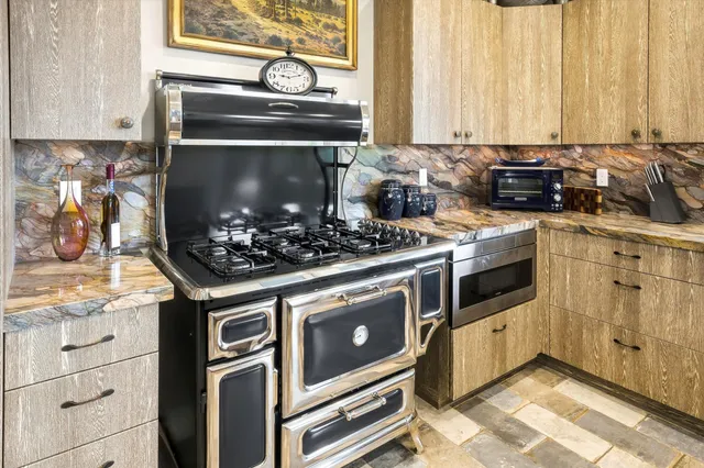 a large kitchen with granite countertop a large counter top stainless steel appliances and cabinets