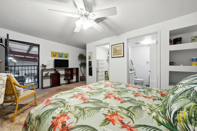 a spacious bedroom with a bed and a flat screen tv