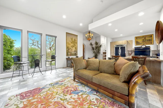 a kitchen with kitchen island granite countertop a stove a refrigerator a dining table and chairs