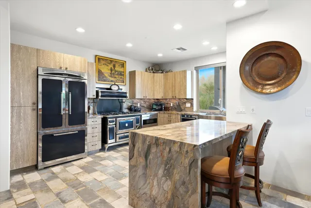 a kitchen with stainless steel appliances granite countertop a stove a refrigerator and a sink