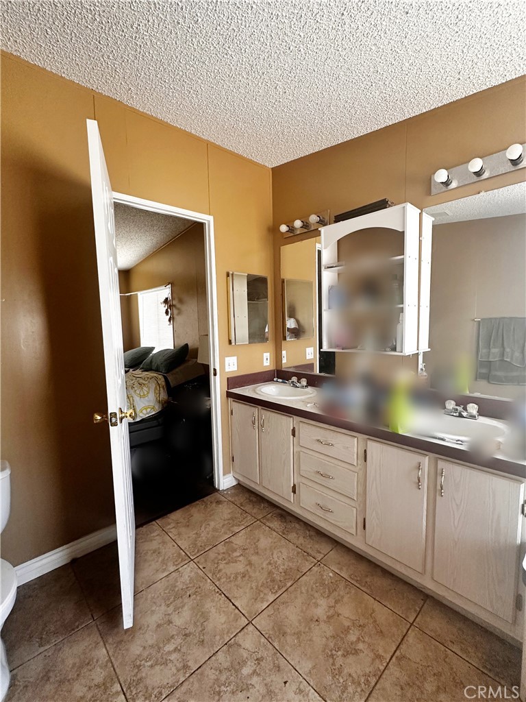 2140 Mentone Boulevard, Unit 97 Mentone, CA 92359 - Photo 10 of 29 a large bathroom with a double vanity sink and a mirror