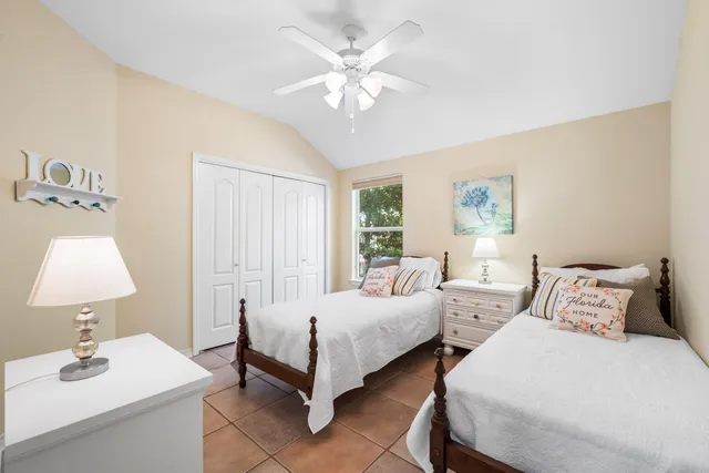 a bedroom with 2 bed and a window