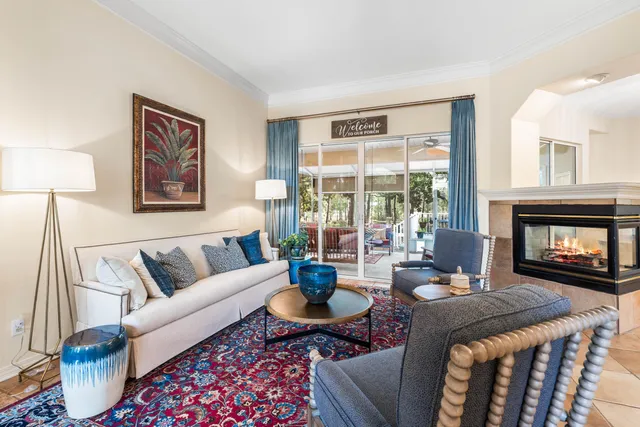 a living room with fireplace furniture and a large window