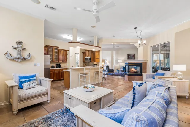 a living room with furniture kitchen view and a chandelier