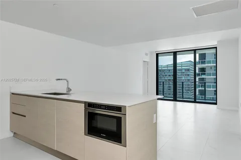 a view of an empty room with a fireplace and a window