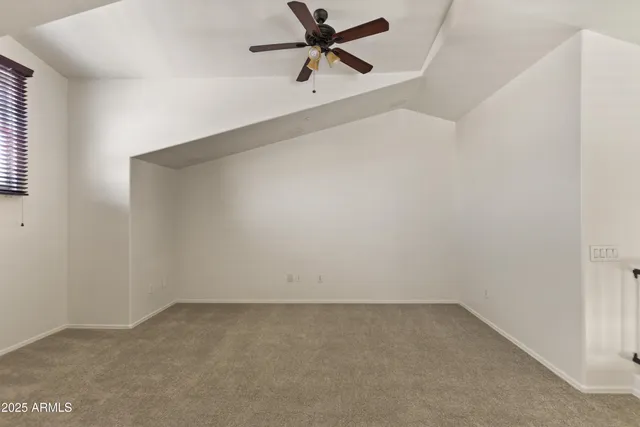 an empty room with a ceiling fan and wooden floor