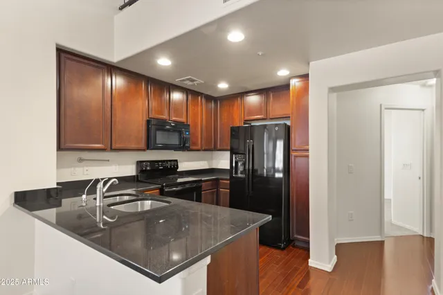 a kitchen with stainless steel appliances granite countertop a sink a stove and a refrigerator