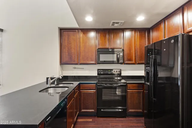 a kitchen with granite countertop stainless steel appliances and wooden cabinets