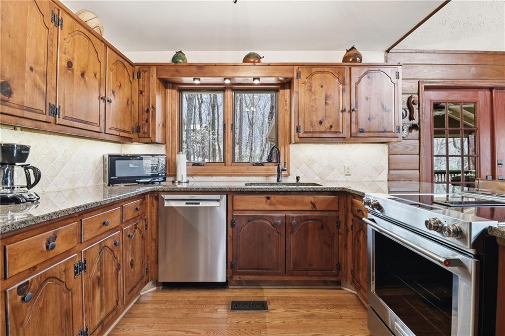 115 Chestnut Oak Point Big Canoe, GA 30143 - Photo 12 of 56 a kitchen with stainless steel appliances granite countertop a sink stove and cabinets