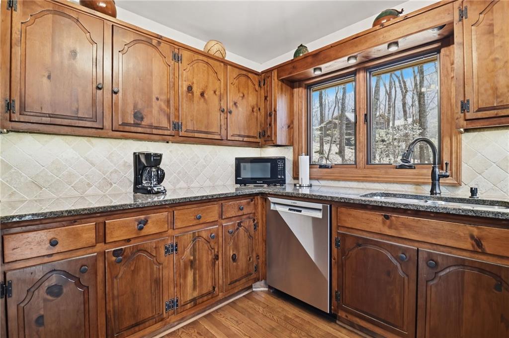 115 Chestnut Oak Point Big Canoe, GA 30143 - Photo 13 of 56 a kitchen with stainless steel appliances granite countertop a sink and cabinets with wooden floor