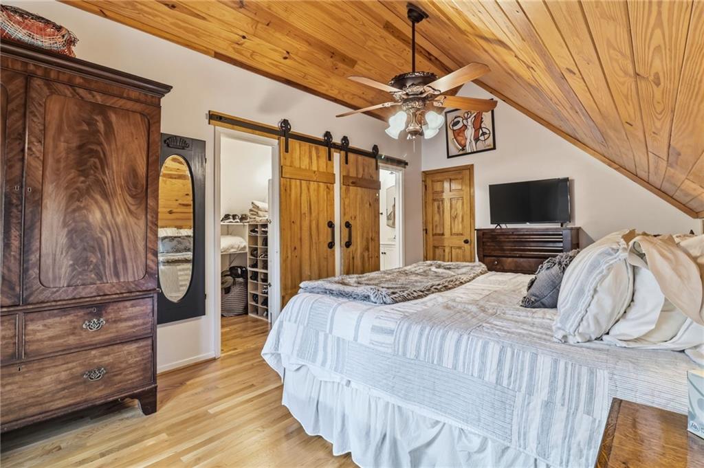 115 Chestnut Oak Point Big Canoe, GA 30143 - Photo 17 of 56 a bedroom with a bed a dresser and flat screen tv