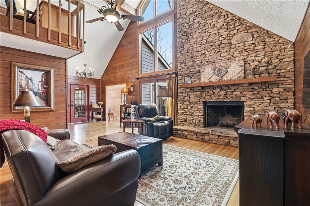 115 Chestnut Oak Point Big Canoe, GA 30143 - Photo 5 of 56 a living room with furniture a flat screen tv and a fireplace