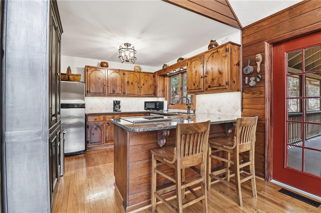 115 Chestnut Oak Point Big Canoe, GA 30143 - Photo 7 of 56 a kitchen with stainless steel appliances kitchen island granite countertop a table and chairs
