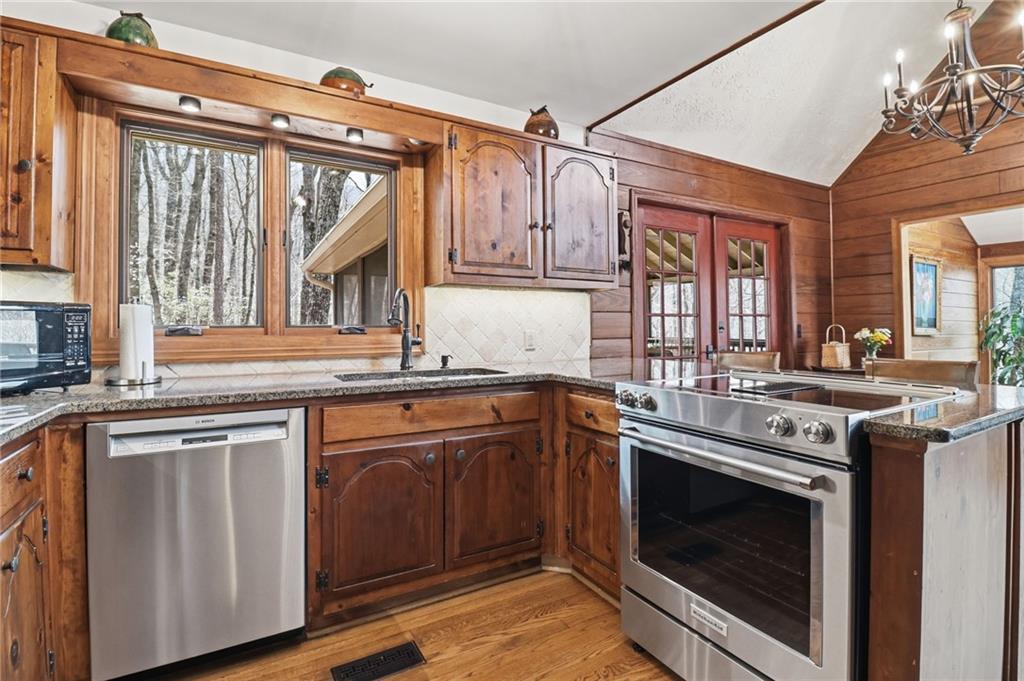 115 Chestnut Oak Point Big Canoe, GA 30143 - Photo 8 of 56 a kitchen with stainless steel appliances granite countertop a stove and a sink