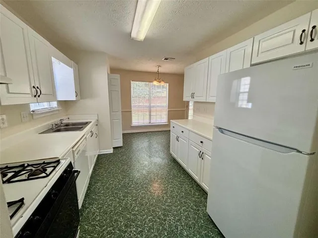 a kitchen with white cabinets and white appliances