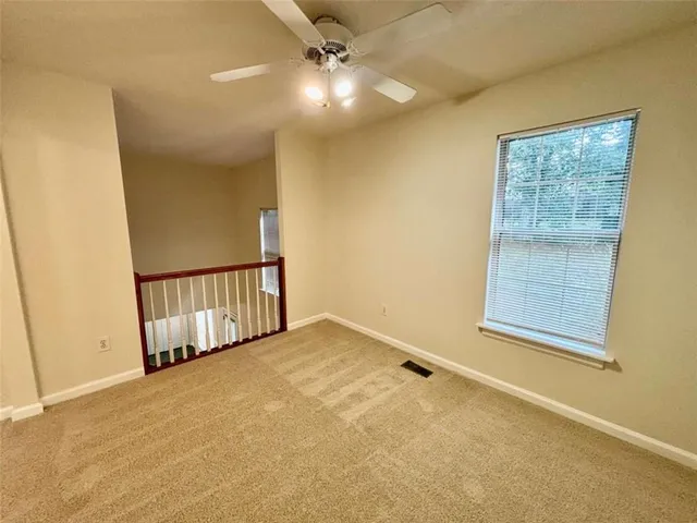 an empty room with windows and fan