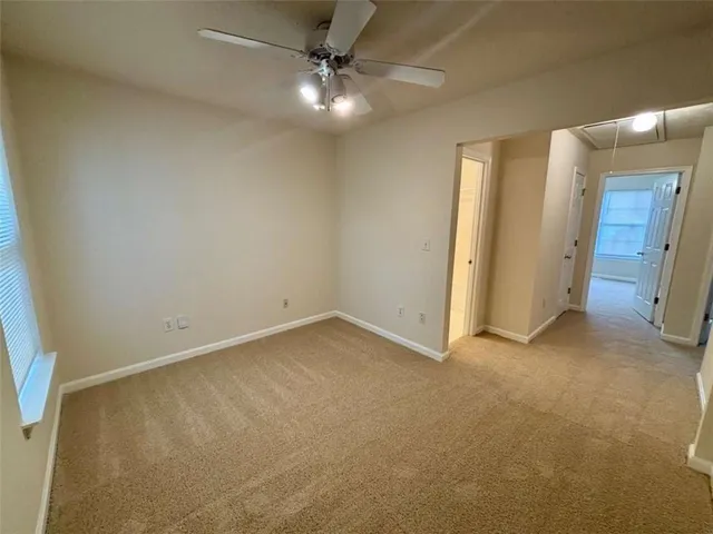 an empty room with a ceiling fan and a window