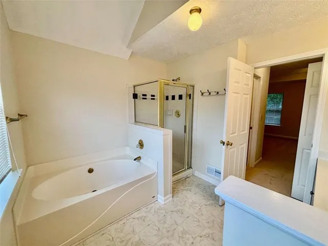 a bathroom with a bathtub and a shower