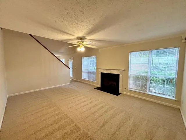 a view of an empty room with a fireplace and a window