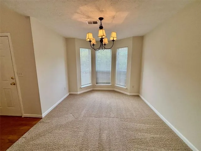 a view of a livingroom with a chandelier fan and wooden floor