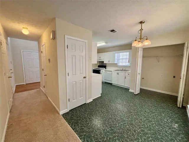 a kitchen with white cabinets and white appliances