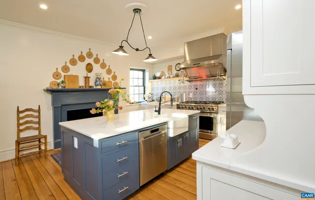 a living room with furniture a chandelier and a fireplace