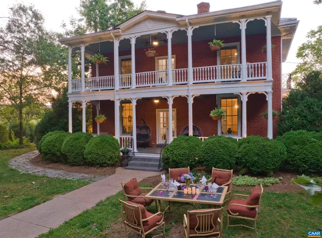 a view of a patio with table and chairs potted plants and a large tree