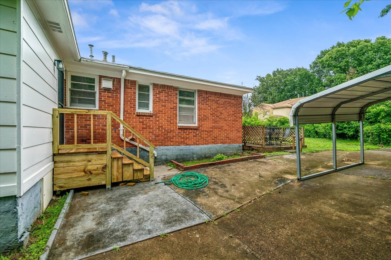 2518 Manchester Road Memphis, TN 38114 - Photo 19 of 23 Exterior featuring a red brick facade, white siding, and a wooden deck with steps