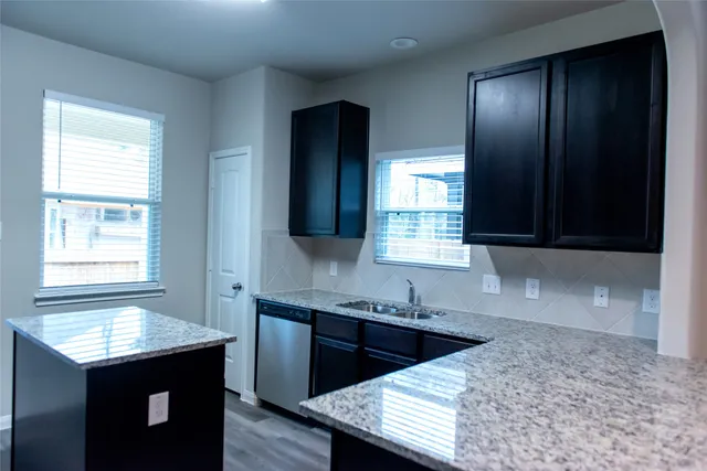 a kitchen with a sink a window and cabinets