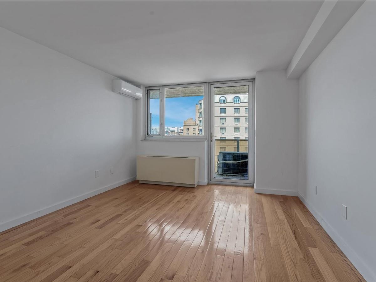133-38 Sanford Avenue, Unit 11C Queens, NY 11355 - Photo 18 of 24 wooden floor in an empty room with a window