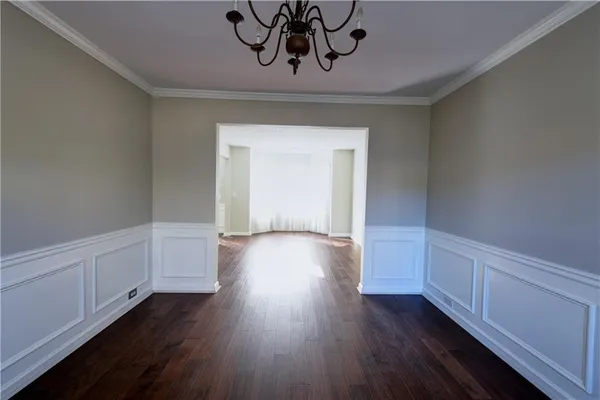 a view of a room with wooden floor and cabinets