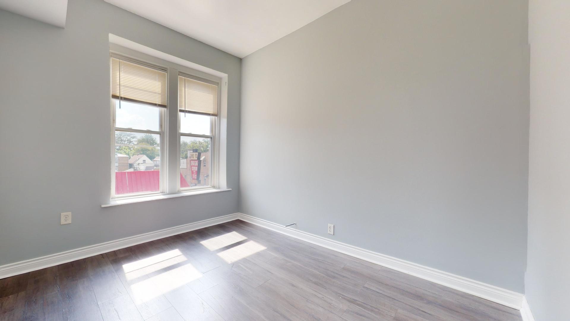 2700 West Cermak Road, Unit 2F Chicago, IL 60608 - Photo 14 of 16 an empty room with wooden floor and windows
