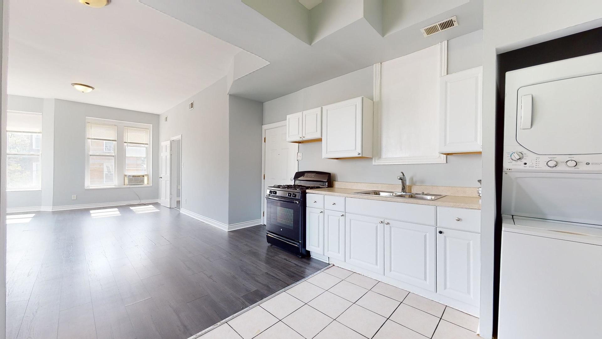 2700 West Cermak Road, Unit 2F Chicago, IL 60608 - Photo 2 of 16 a kitchen with a sink cabinets and wooden floor