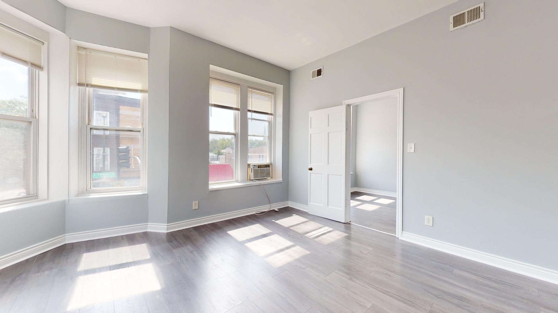 2700 West Cermak Road, Unit 2F Chicago, IL 60608 - Photo 5 of 16 an empty room with wooden floor and windows
