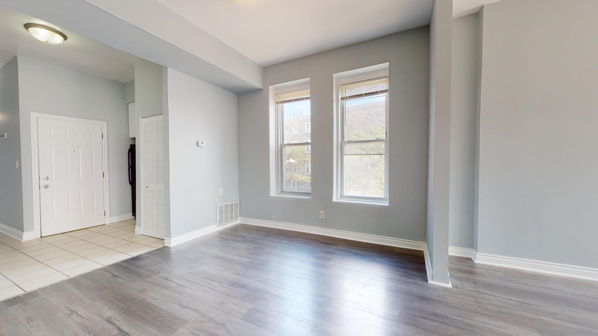 2700 West Cermak Road, Unit 2F Chicago, IL 60608 - Photo 6 of 16 an empty room with wooden floor and windows