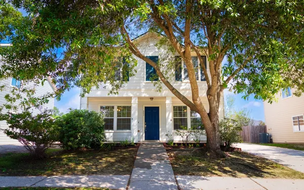 a front view of a house with a tree