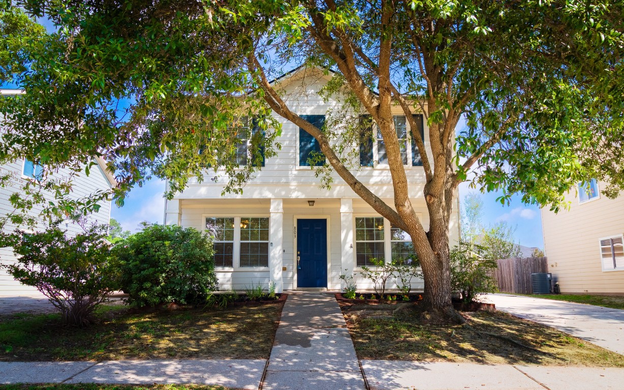 a front view of a house with a tree