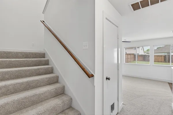 a view of staircase with white walls and windows