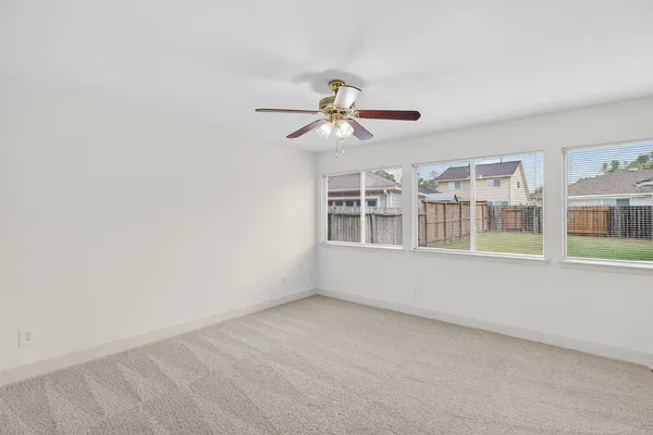 a view of a room with a ceiling fan and window