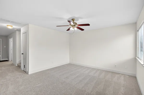 a view of a room with a ceiling fan and a window