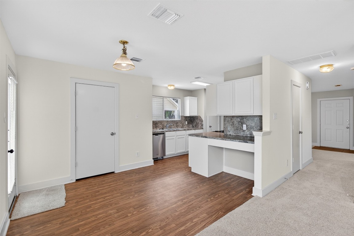 803 Dragonfly Drive Conroe, TX 77301 - Photo 17 of 50 a open kitchen with white cabinets and wooden floor