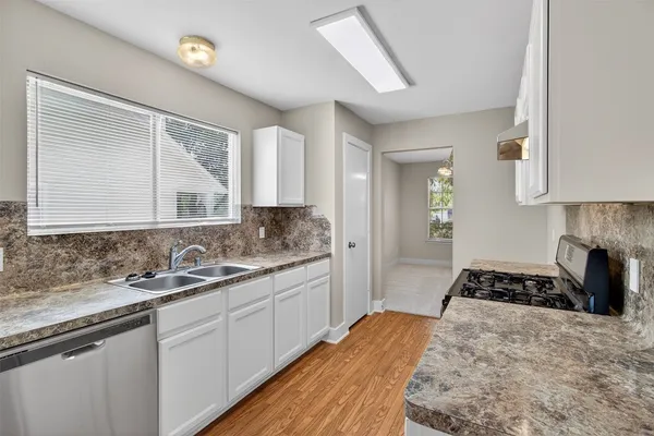 a kitchen with a sink stove and cabinets