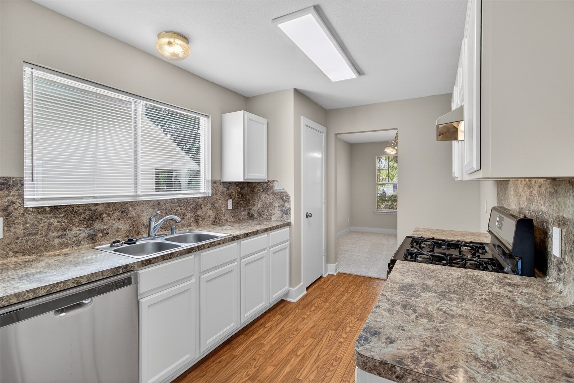 803 Dragonfly Drive Conroe, TX 77301 - Photo 19 of 50 a kitchen with a sink stove and cabinets