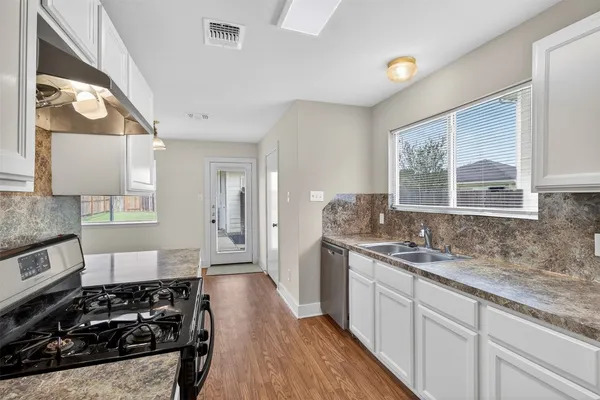 a kitchen with a stove a sink and a granite counter tops