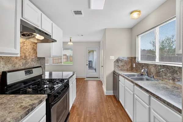 a kitchen with stainless steel appliances granite countertop a stove and a sink